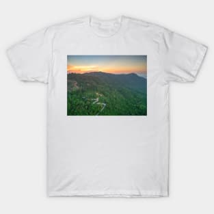 Aerial view of curvy mountain road through a jungle ay sunset T-Shirt